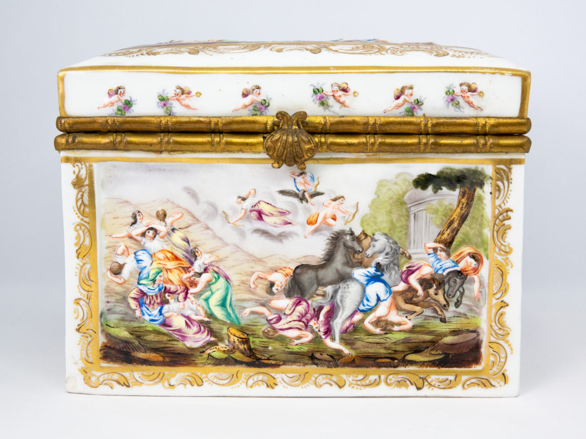 Late 19th century Naples porcelain box. A heavy porcelain box moulded in high relief with scenes of scantily clad men and women disporting themselves in various ways. Beautifully hand-painted in bright vibrant colours and finished off with gilt accent. Photo of front of box. Decoration shows cupids? firing arrows of love to with group of women reclining on the left and men falling off horse to the right.