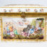 Late 19th century Naples porcelain box. A heavy porcelain box moulded in high relief with scenes of scantily clad men and women disporting themselves in various ways. Beautifully hand-painted in bright vibrant colours and finished off with gilt accent. Photo of front of box. Decoration shows cupids? firing arrows of love to with group of women reclining on the left and men falling off horse to the right.