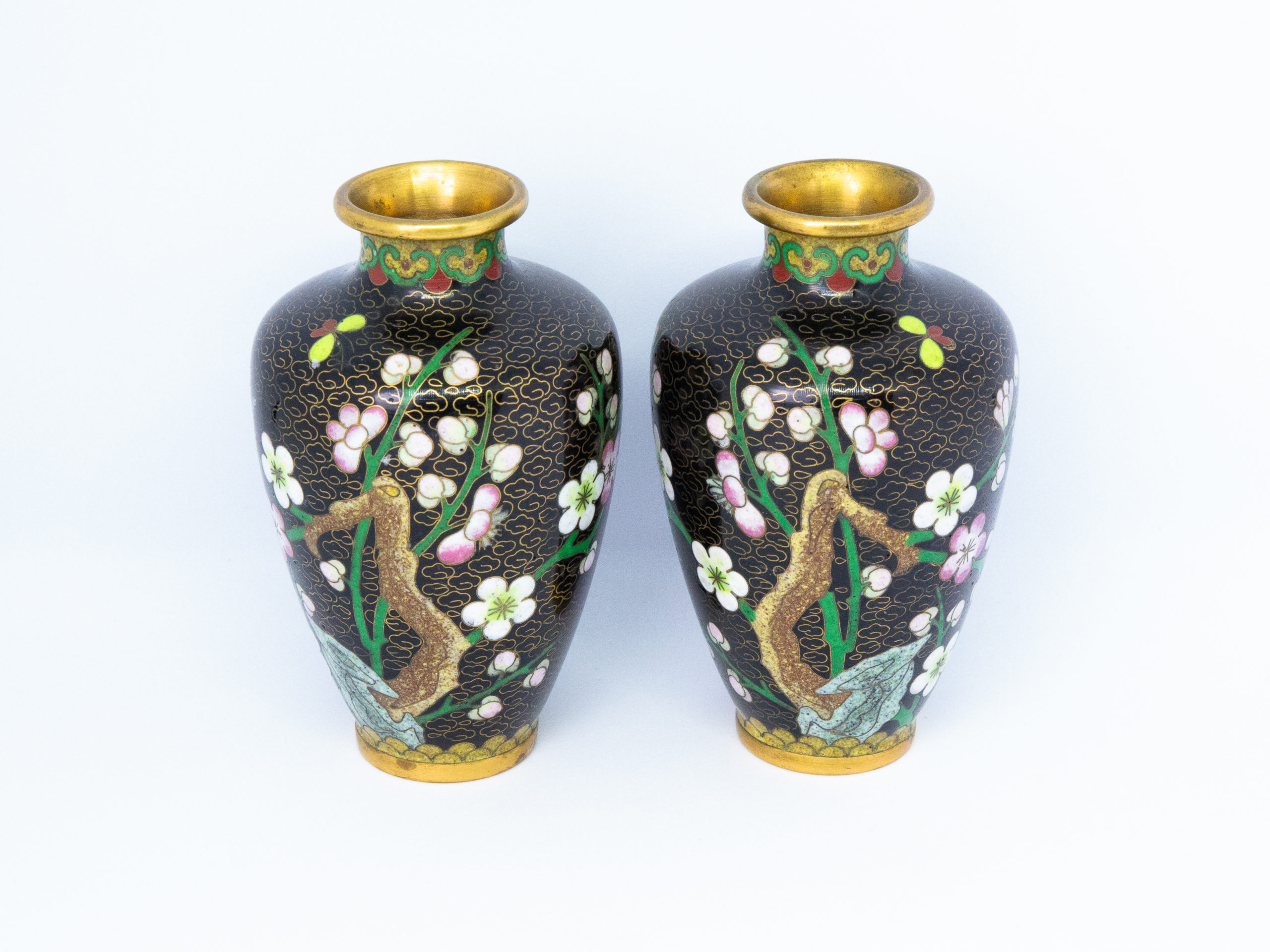 Pair of small mirror image cloisonné vases. Pretty and striking pair of cloisonné vases with mirror image of plum blossoms. The black background brings out the beautiful colour detail of the decoration. Measures 32mm in diameter at base and top and 60mm in diameter at widest area towards top of the vase. Main photo of the 2 vases displayed side by side and shown from the mirror image plum blossom side.