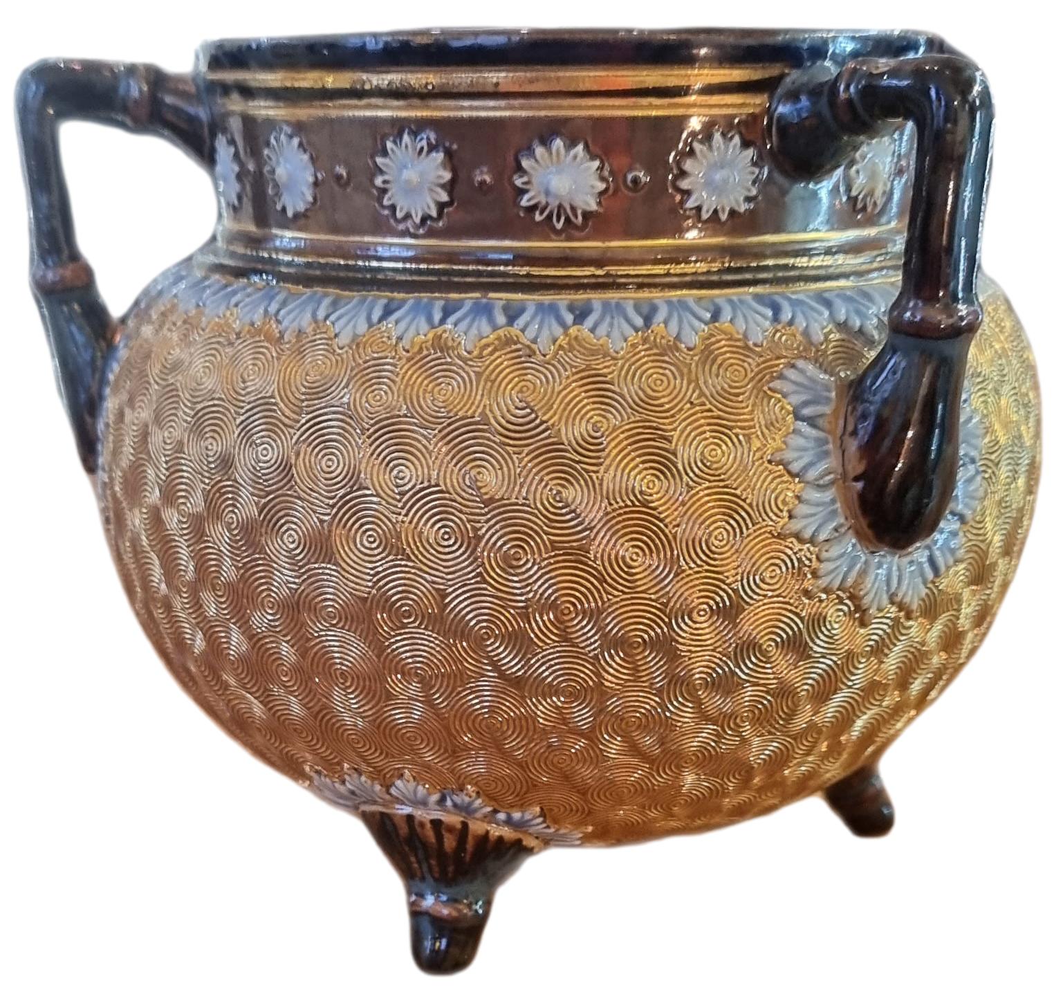 Royal Doulton pot circa 1904. Three Handled squat pot with gold spiral decoration to its body and brown glazed handles and rim with a touch of blue highlights. Main photo showing the pot from an eye level angle with 2 handles and 2 legs visible.