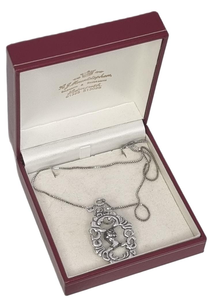 The Victorian Putti is in 925 silver and features the face of a cherub inside a decorative oval open pendant. The pendant is supported by a silver cube chain, the pendant and chain are in good condition and would make a great gift idea. Main photo of necklace displayed inside its box
