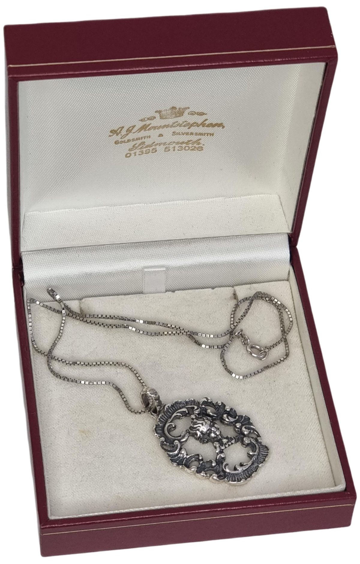 The Victorian Putti is in 925 silver and features the face of a cherub inside a decorative oval open pendant. The pendant is supported by a silver cube chain, the pendant and chain are in good condition and would make a great gift idea. Photo of necklace displayed in its box.