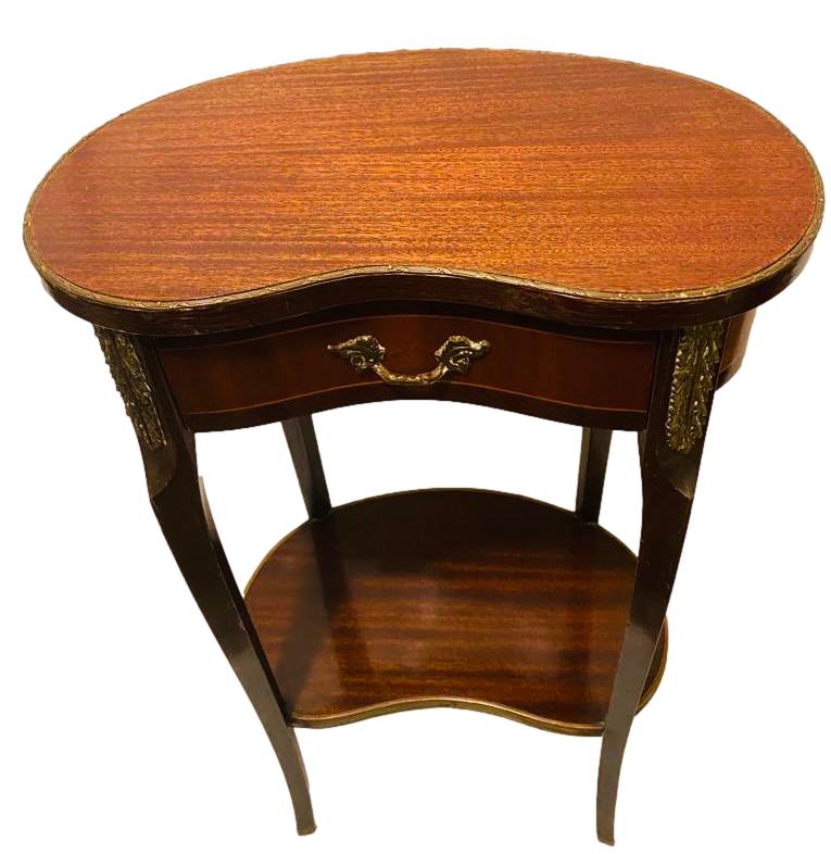Mahogany kidney shaped table decorated with ormolu trimmings. Main photo looking at table from the front and looking slightly down.