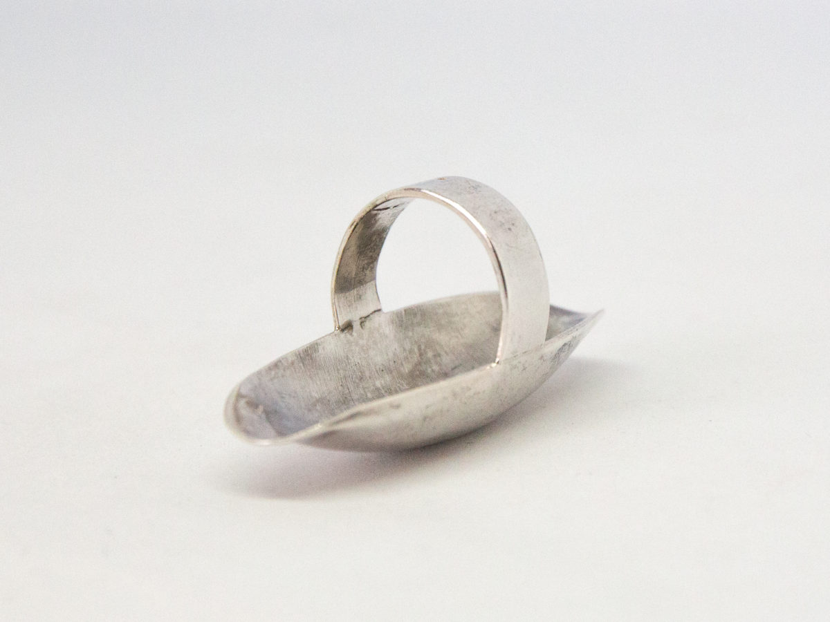Modern sterling silver statement ring. Amazing solid sterling silver statement ring that covers most of the lower half of the finger. Upward curves at both ends ensure no digging into skin. Full hallmark to the outer band at back for London assay c2001. Ring front measures 55mm long and 20mm at widest. Ring size N / 6.5. Photo of ring with front face down on a flat surface and showing the band at top.