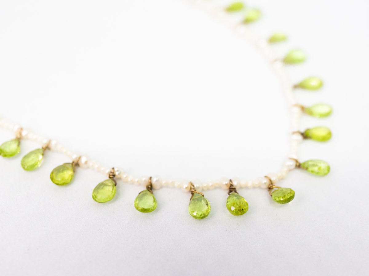 Modern seed pearl and peridot necklace. Very pretty and dainty necklace of seed pearls with teardrop faceted peridot briolette beads to the front finished with a gilt silver clasp. Very elegant classical look. (Some gilt wear to ring clasps). Close up photo of some of the peridot briolette beads.