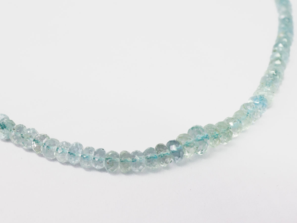 Modern aquamarine bead necklace. Pretty necklace made up entirely of graduating faceted aquamarine stones beautifully strung and finished with a sterling silver clasp. Close up photo of the larger faceted aquamarine stones at the front of necklace.