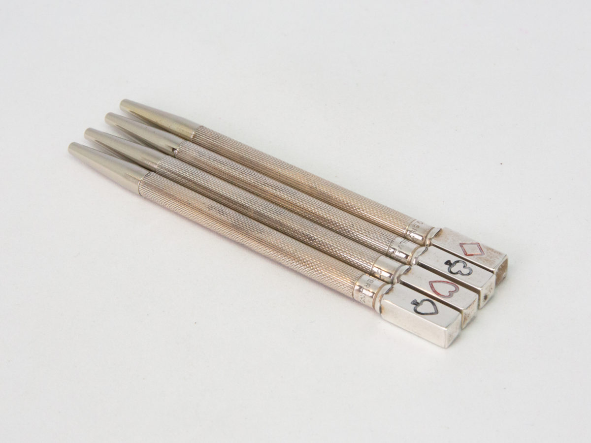 Set of sterling silver Bridge pencils. Lovely boxed set of 4 sterling silver propelling pencils with a card suit on the end of each pencil. All 4 pencils are hallmarked Sterling Silver with each one measuring 85mm and weighing approximately 6.5gms Photo of all 4 pencils laid side by side outside of the case with pencil tip end in top left corner of photo.