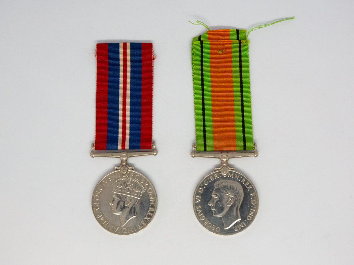 Un-issued Defence and War medal 1939-45. 2 medals from WWII namely The Defence medal and The War Medal. Both medals are un-issued. Small certificate from the Under-Secretary of State for War naming Gnr H. C. Compton who died in service. Each medal measures 36mm in diameter and are in excellent condition with ribbons in good condition. Photo of both medals side by side showing the obverse side .