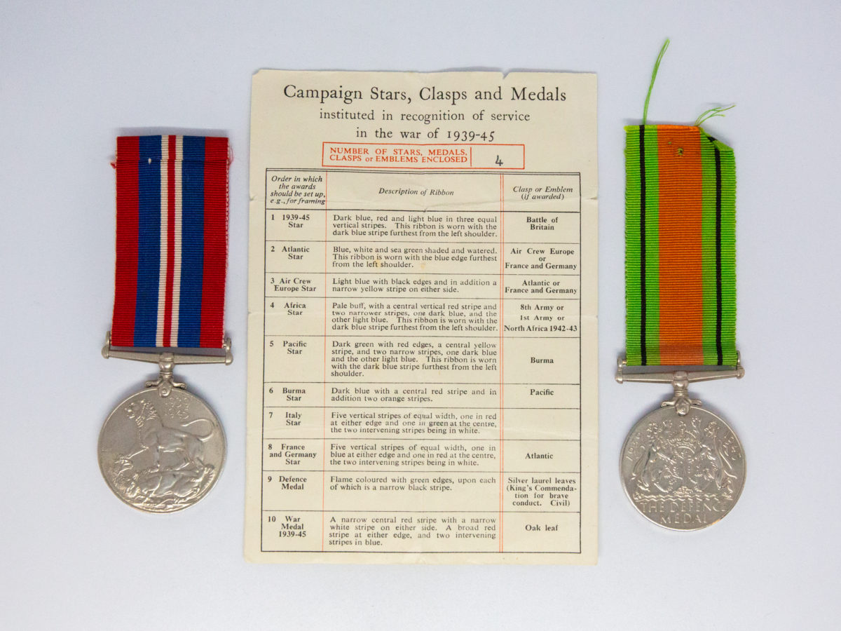 Un-issued Defence and War medal 1939-45. 2 medals from WWII namely The Defence medal and The War Medal. Both medals are un-issued. Small certificate from the Under-Secretary of State for War naming Gnr H. C. Compton who died in service. Each medal measures 36mm in diameter and are in excellent condition with ribbons in good condition. Photo of the 2 medals one either side of the certificate showing list of medal contents (List says 4 medals enclosed but only 2 are available)