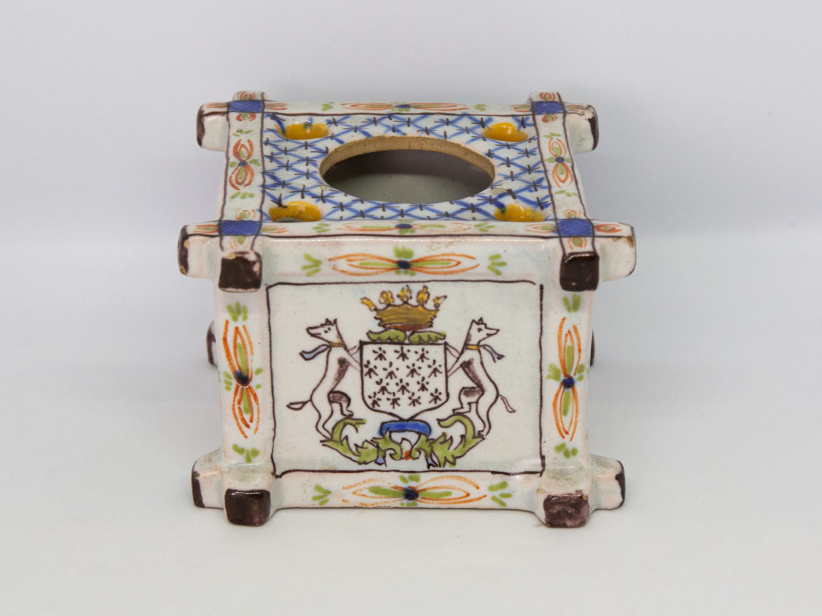 Late 19th century Faience inkwell. Antique inkwell attributed to Quimper and dated 1879 to the base. Beautifully hand painted in typical Quimper pottery colours with Brittany coat of arms and woman in traditional Breton costume. A couple of chips to the corners but otherwise in excellent condition for its age. Photo of side of inkwell showing a coat of arms.