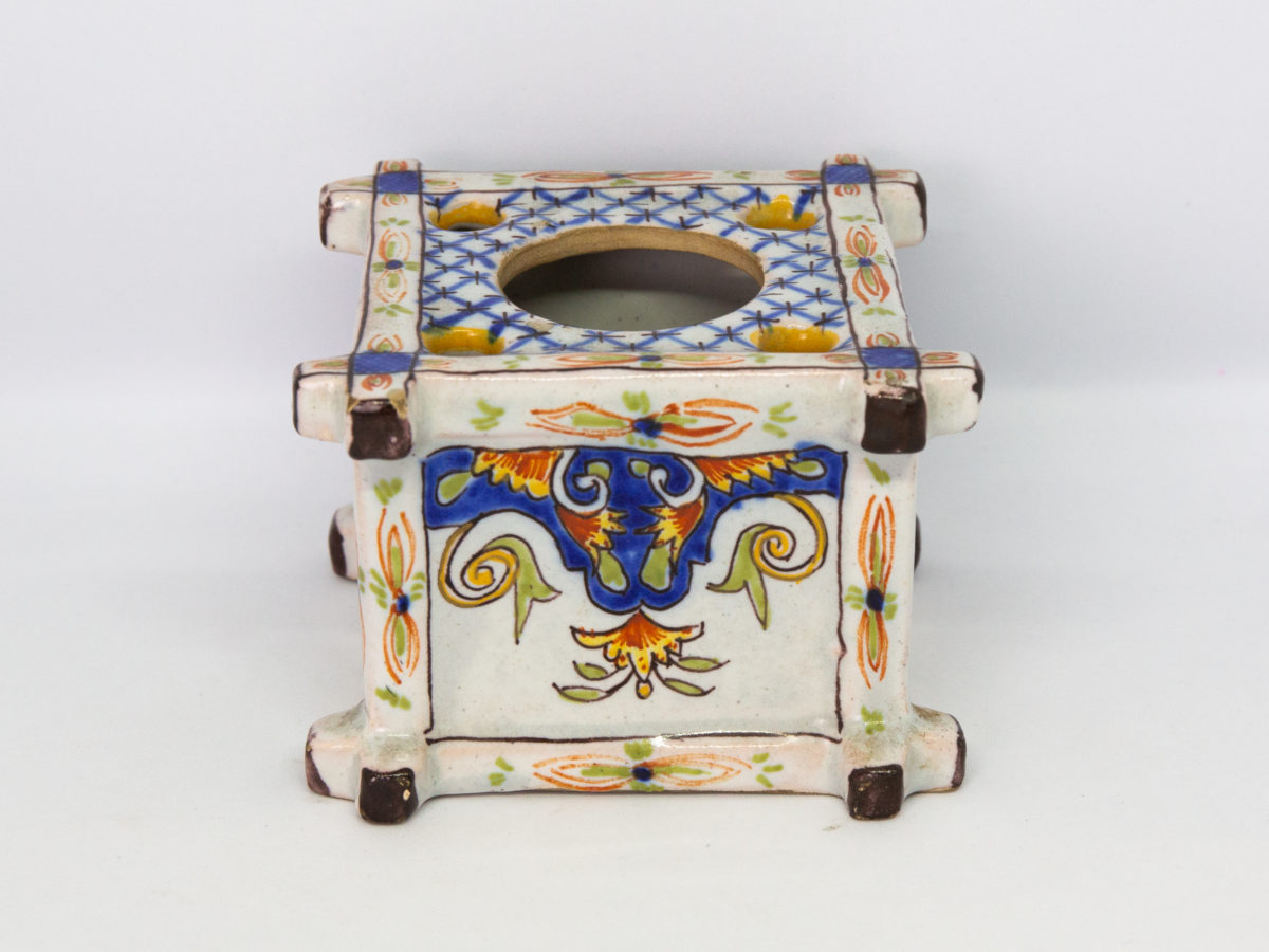 Late 19th century Faience inkwell. Antique inkwell attributed to Quimper and dated 1879 to the base. Beautifully hand painted in typical Quimper pottery colours with Brittany coat of arms and woman in traditional Breton costume. A couple of chips to the corners but otherwise in excellent condition for its age. Photo of side of inkwell with bright coloured decoration.