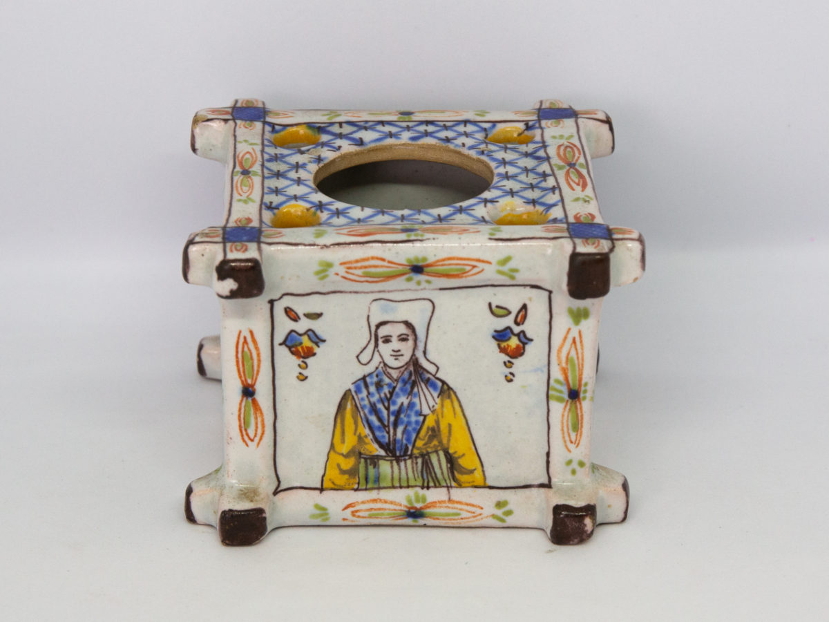 Late 19th century Faience inkwell. Antique inkwell attributed to Quimper and dated 1879 to the base. Beautifully hand painted in typical Quimper pottery colours with Brittany coat of arms and woman in traditional Breton costume. A couple of chips to the corners but otherwise in excellent condition for its age. Photo of side of inkwell showing a Breton woman in traditional costume.