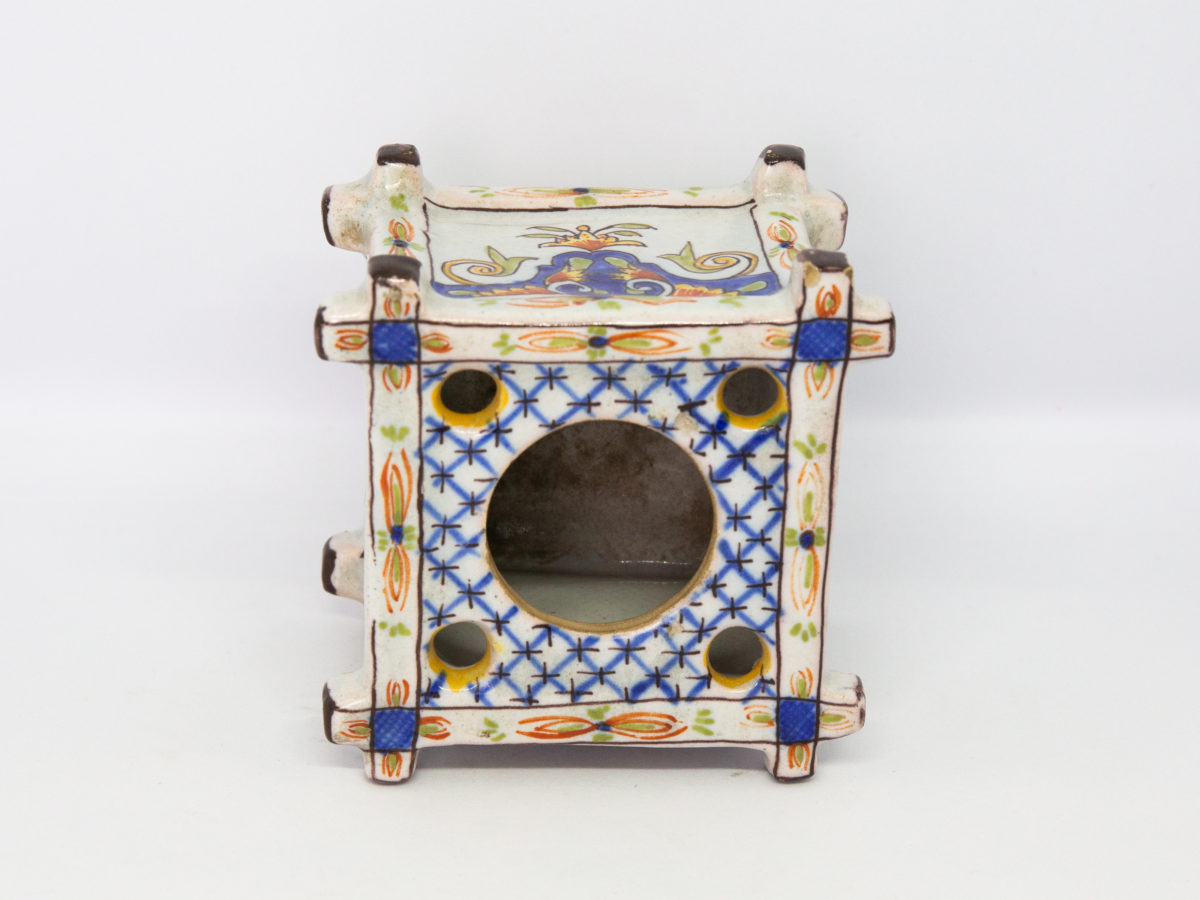 Late 19th century Faience inkwell. Antique inkwell attributed to Quimper and dated 1879 to the base. Beautifully hand painted in typical Quimper pottery colours with Brittany coat of arms and woman in traditional Breton costume. A couple of chips to the corners but otherwise in excellent condition for its age. Photo of inkwell placed on its side showing the blue and white chequered design to the top with one large central hole and 4 smaller holes in the corners for the pens.