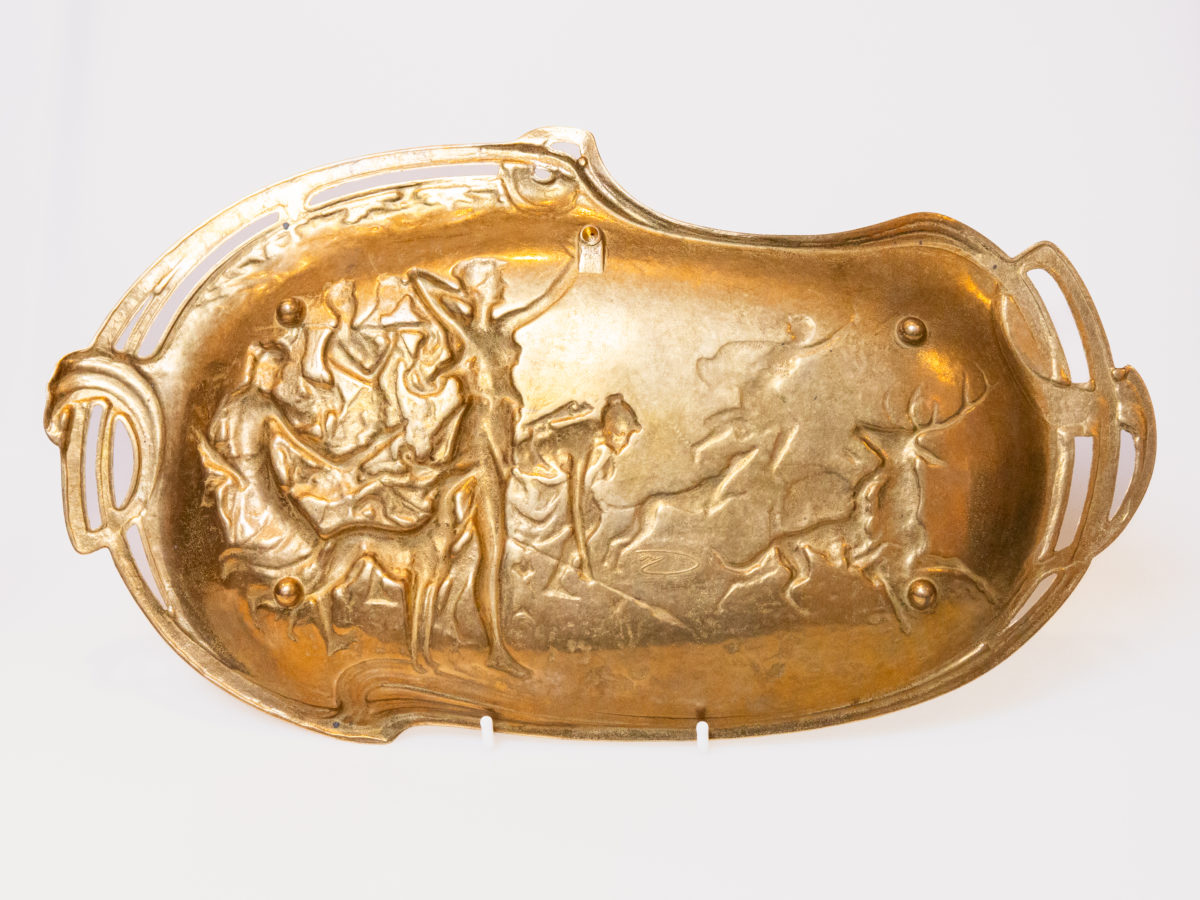Antique Art Nouveau brass wall plaque or tray. A highly decorative brass wall plaque with a typically Art Nouveau look depicting a scene of the Goddess Diana on a hunt. There is a signature to the back which is hard to read but believed to be of French origin. Photo of the reverse of plaque.