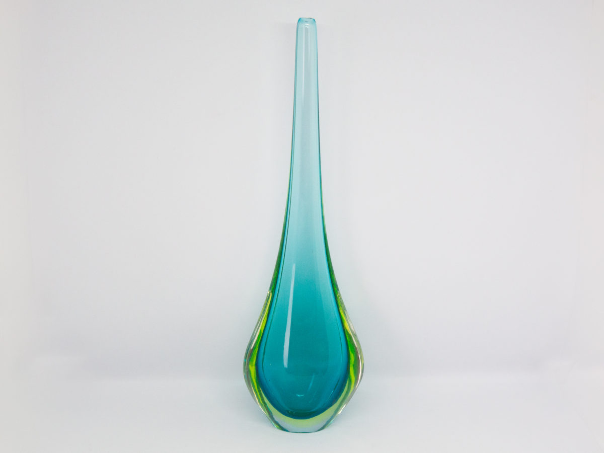 Vintage turquoise glass vase by Murano. Striking slender sommerso glass vase by Murano in stunning turquoise with vibrant sea green to the lower sides. The aesthetically stunning shape is akin to a drop of water and is very pleasing to the eye. A wonderful vintage glass art attributed to Flavio Poli. c1960s. Base measures 42mm by 30mm, the bulbous lower are measures 90mm wide by 60mm deep and top measures 12mm in diameter. The opening at top is very small measuring approximately 6mm in diameter. Main photo of vase with widest and flattest side shown and vibrant green to lowers sides visible.