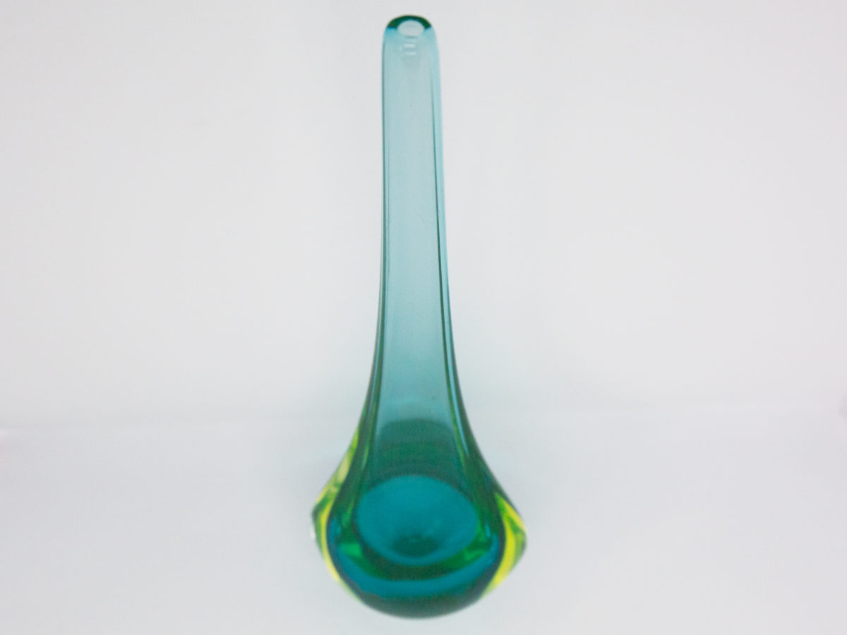 Vintage turquoise glass vase by Murano. Striking slender sommerso glass vase by Murano in stunning turquoise with vibrant sea green to the lower sides. The aesthetically stunning shape is akin to a drop of water and is very pleasing to the eye. A wonderful vintage glass art attributed to Flavio Poli. c1960s. Base measures 42mm by 30mm, the bulbous lower are measures 90mm wide by 60mm deep and top measures 12mm in diameter. The opening at top is very small measuring approximately 6mm in diameter. Photo of vase seen from a slightly raised angle .