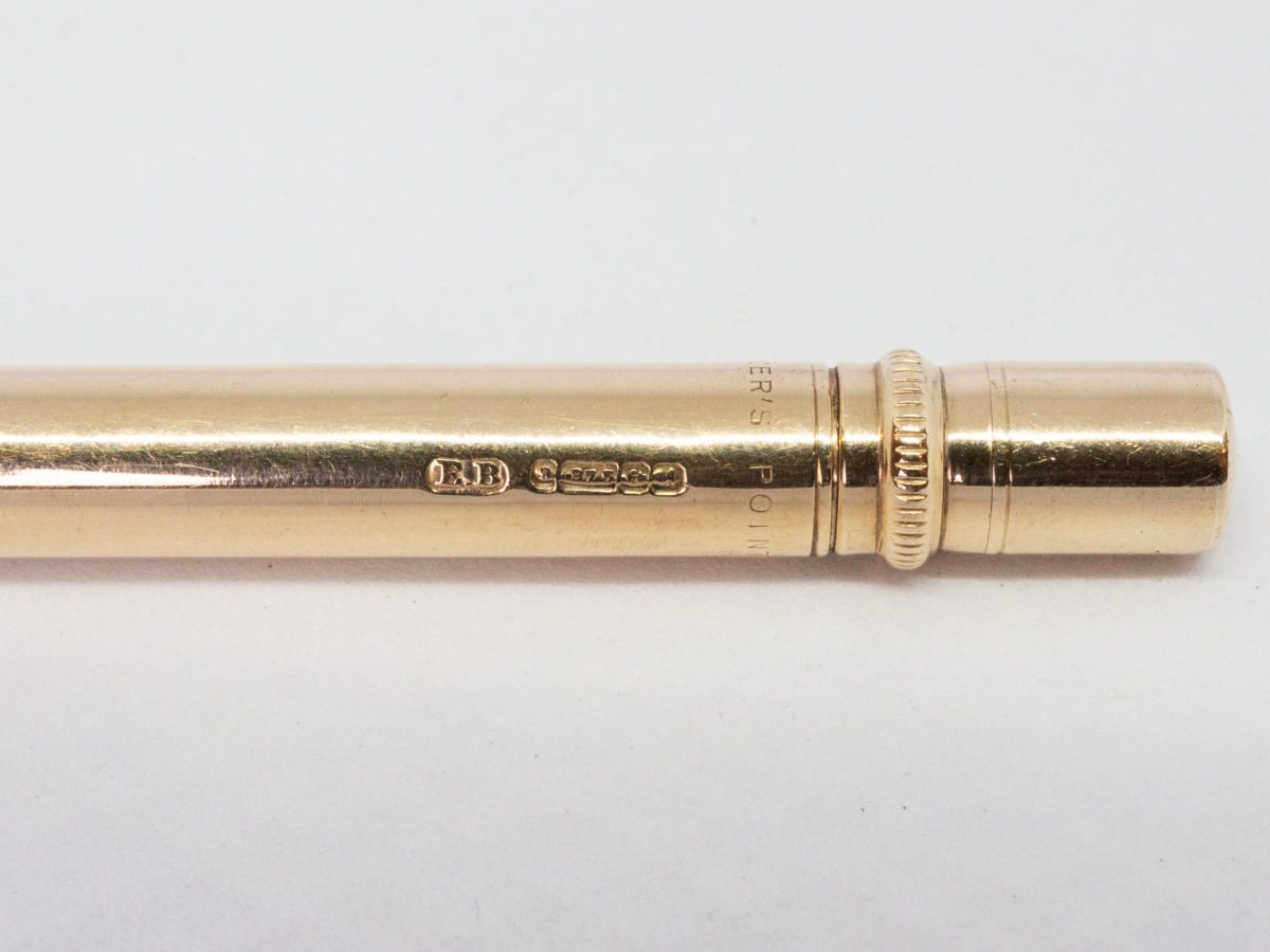 Vintage 9 karat gold propelling pencil. Very fine quality 9 karat gold pointer propelling pencil in excellent condition and working order. Fully hallmark for Birmingham assay c1975 and made by E. Baker & Son. Close up photo of the full hallmark on the side of the pencil.