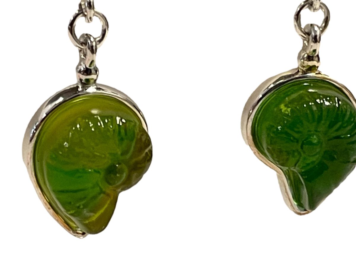 "Sound of the Ocean" earrings by Liuli Gong Fang. Made in sterling silver and green pâte-de-verre crystal in the form of a shell. Drop length approximately 40mm. Close up photo of the crystal shell part of earrings.