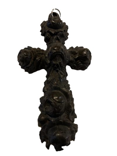 Vintage vulcanite cross carved from one piece of vulcanite. Intricately decorated with roses in a 3d effect. Main photo of the cross seen from the front.