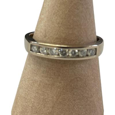 This ring is 18 karat gold set with a quarter of a carat of diamonds. It is a half hoop eternity ring stamped 18 ct & .25 inside the shank. Ring size L. Ring weight 2.1 grams. Main photo of ring on a cone shaped stand and seen with ring front facing forward,