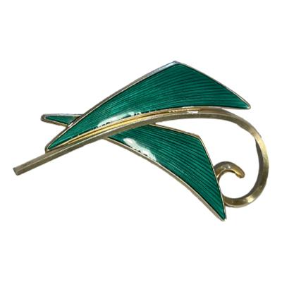 Gilt sterling silver mid 20th century brooch with green enamel by Albert Scharning, Norway. Lovely modernist leaf design with gilt silver back. Full hallmark to the back of brooch. Main photo of brooch front laid in a sideways angle.