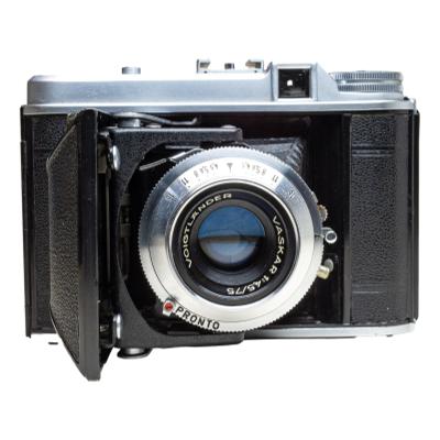 Medium format folding camera from 1950s. Takes 120 size film, 6×6 cm (2¼-inch square) Main photo of camera seen from the front looking directly at lens.