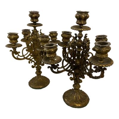 Pair of vintage brass candelabra candlesticks. Highly decorative pair of brass candlelabras with sconces for 5 candles per candlestick. The sconces & drip trays can be removed for easy cleaning. Each measures approximately 310mm tall Gap for candle is 25mm in diameter. COLLECT FROM STORE ONLY. Main photos of both candelabras displayed side by side with one slightly in front of the other.
