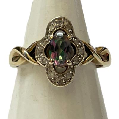 A 9ct gold Gypsy ring size M with a colourful Mystic stone and diamond setting. Main photo of ring on a cone shaped display stand with ring front facing forward.