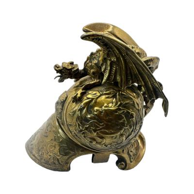 Victorian Brass Helmet Dragon/Griffin Inkwell. The pot which contained the ink is missing but does not deflect from the fine quality and workmanship of this piece.  COLLECT FROM STORE ONLY. Main photo of helmet inkwell seen from a side view showing the shape of the helmet and the dragon/griffin on top with wings spread.
