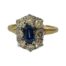 Vintage 18 karat gold ring set with an emerald cut cornflower blue sapphire to centre and a frame of 8 brilliant classic round cut diamonds. Gems are set on 18 karat white gold with an 18 karat yellow gold band. Ring size L.5 / 6. Box included (may not be box shown). Main photo of ring shown with ring front forward facing.