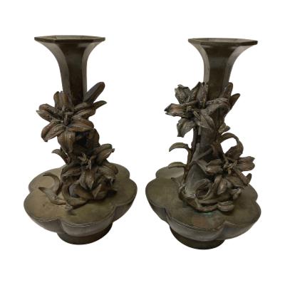 Pair of small bronze vases from the 17th-18th century Qing era, China. Near identical hexagonal vases with bronze lilies decorating the slim necks of each vase. The base measures 55mm in diameter, widest area 105mm in diameter and top measures 46mm in diameter. Each vase is 180mm tall. HEAVY - COLLECT FROM STORE ONLY. Main photo of both vases displayed side by side with lilies facing forward.