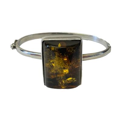 Modernist, vintage 925 silver amber bangle. The bangle has a Czech silver hallmark ( 1949 -1962 ). The amber has a lot of attractive seed inclusions & measures 25 x 30 x 15. The internal diameter of the bangle is 60 mms x 45 mms. Weight 27.9 grams. Main photo of bracelet seen with the large amber at the front. The clasp area can be seen to the left.