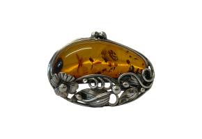 Art Nouveau style amber brooch. Amber brooch set in a 925 sterling silver frame with floral design in an Art Nouveau style. Hallmarked 925 to the brooch pin. Main photo of brooch front with the floral area of silver to the bottom and amber area at the top.