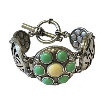 Graduated round panel bracelet. A fun bracelet with 5 round panels. The largest central disc is decorated with green and yellow , on either side there are plain silver discs with cut out pattern and smallest discs at either end with red centre. No visible hallmark but tested as 800 silver. Central disc measures 35mm in diameter. Main photo showing bracelet displayed upright with clasp closed. The main centre panel is in the foreground and the clasp is to the centre back and closed.