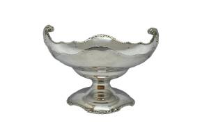 George V sterling silver tazza. Substantial stetling silver tazza by Mappin & Webb. Elegant design featuring twist pattern edging around the base and bowl with fleurs de lis style scrollwork handles. Full hallmark to outside of bowl for London assay c1932 and full Mappin and Webb stamp to the base. Base measures 146mm in diameter. 25 Troy ounces. COLLECT FROM STORE ONLY. Main photo of tazza from a near eye level angle with the fleurs-de-lis handles to the left and to the right.